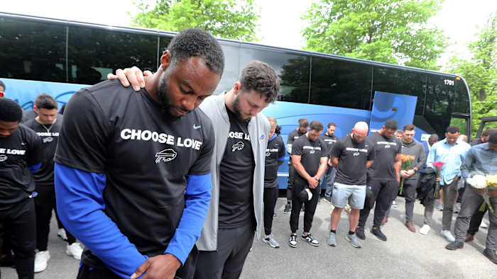 Buffalo Bills running back Taiwan Jones and Quarterback Josh Allen pray with their teammates near the site of the last Saturday's mass shooting at the Tops supermarket in Buffalo, N.Y. May 18, 2022. Members or the team visited the site and then helped distribute food to members of the community
